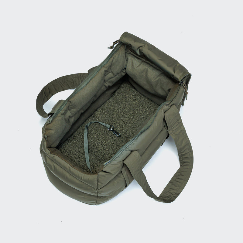 Green backpack with open lid on a light gray background