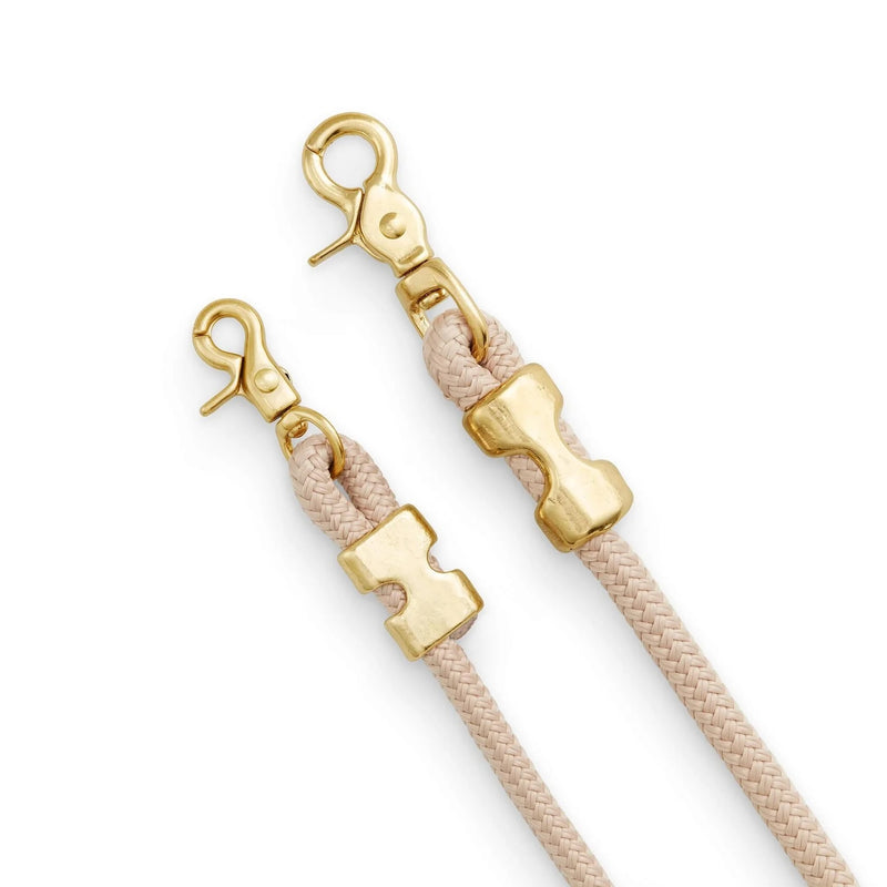 Gold and beige strap ends with clasp on a white background