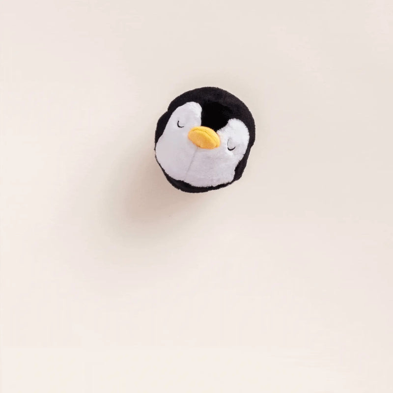 Plush penguin toy on a light beige background