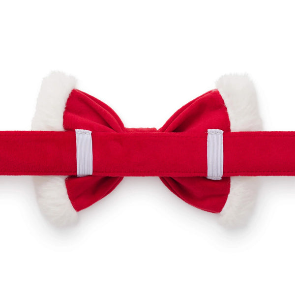 Red bow tie with white fur trim on a white background