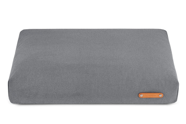 Gray fabric cushion with an orange label on a white background