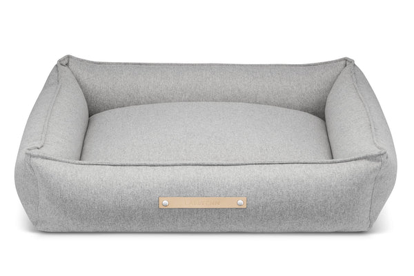 Gray pet bed with a gold label on a white background