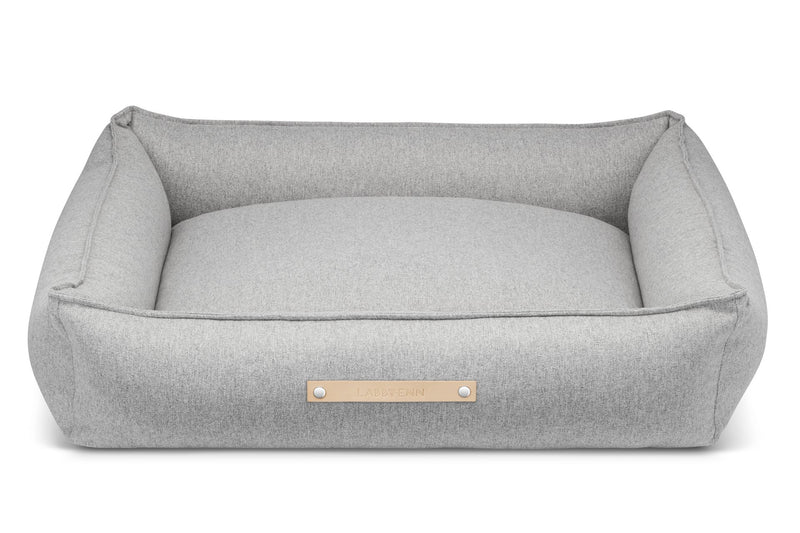 Gray pet bed with a gold label on a white background